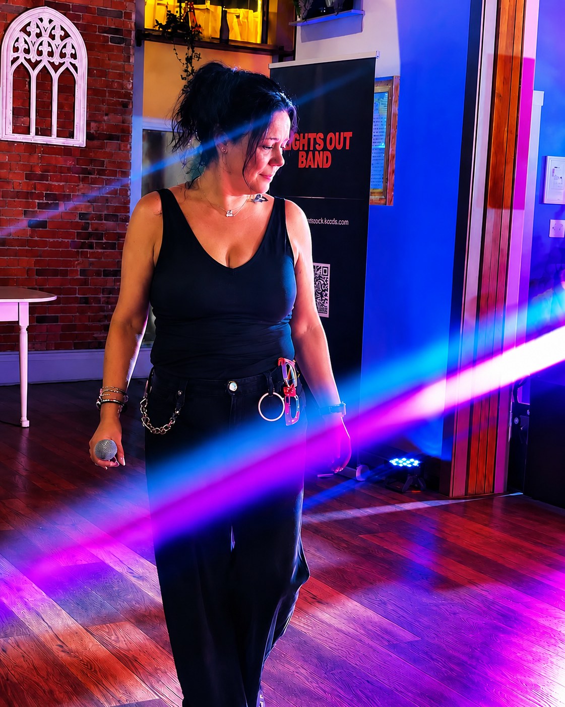 Lights Out lead singer performing with a microphone at an indoor venue